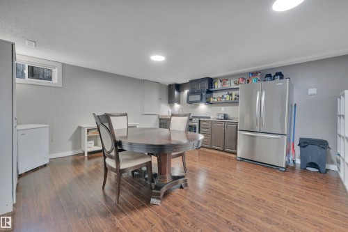 This open-concept room features hardwood floors, light gray walls, and recessed lighting - 8807 31 Avenue, Edmonton, AB - Indoor Photo Showing Dining Room