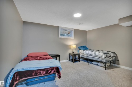This room features light grey walls, light grey carpeting, and a window providing natural light - 8807 31 Avenue, Edmonton, AB - Indoor Photo Showing Bedroom