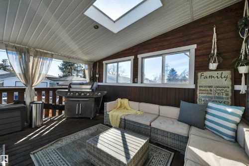 The property features a covered patio with a skylight, wood paneled walls, and a wooden deck - 8807 31 Avenue, Edmonton, AB - Outdoor With Deck Patio Veranda With Exterior