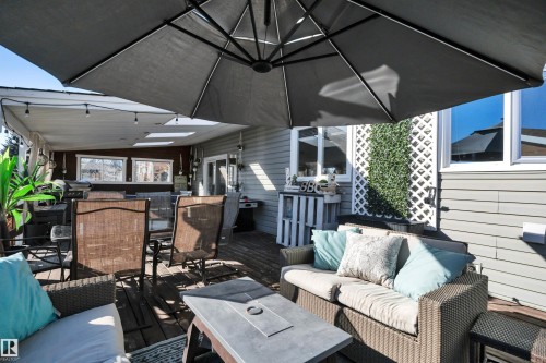 Expansive outdoor deck area with a covered section, overhead lighting, and skylights - 8807 31 Avenue, Edmonton, AB - Outdoor With Deck Patio Veranda With Exterior