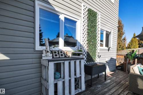 The property features a wood deck and a light gray exterior with white trim around the windows - 8807 31 Avenue, Edmonton, AB - Outdoor With Deck Patio Veranda With Exterior