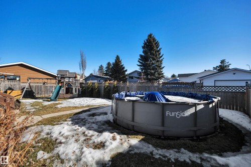 The property features a fenced backyard with a lawn and an above-ground pool - 8807 31 Avenue, Edmonton, AB - Outdoor With Above Ground Pool