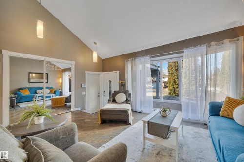 Spacious living area featuring a vaulted ceiling, recessed lighting, and large windows that provide abundant natural light - 8807 31 Avenue, Edmonton, AB - Indoor Photo Showing Living Room
