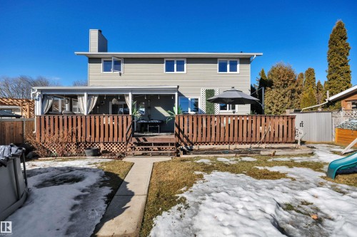 The property features a two-story exterior with light-colored siding, a wooden deck, and a fenced yard - 8807 31 Avenue, Edmonton, AB - Outdoor With Deck Patio Veranda