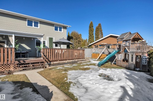 The property features a large wooden deck with latticework detailing, providing an inviting outdoor living space - 8807 31 Avenue, Edmonton, AB - Outdoor With Deck Patio Veranda