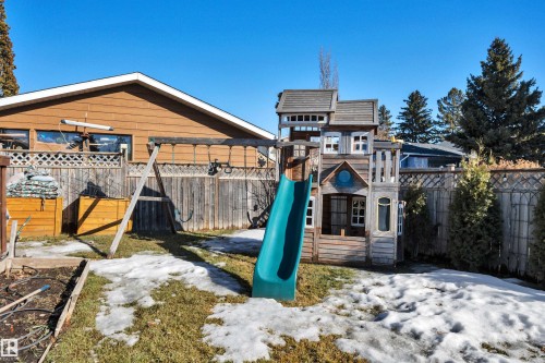 The property features a fenced backyard with a lawn and mature trees - 8807 31 Avenue, Edmonton, AB - Outdoor