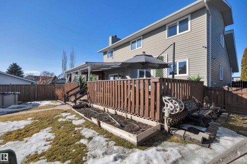 The property features a fenced yard, a raised wooden deck with a covered area, and a garden bed - 8807 31 Avenue, Edmonton, AB - Outdoor