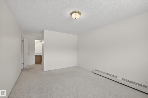 This room features light-colored carpeting, white walls, and a ceiling light fixture - 106 15499 Castle Downs Road, Edmonton, AB - Indoor Photo Showing Other Room
