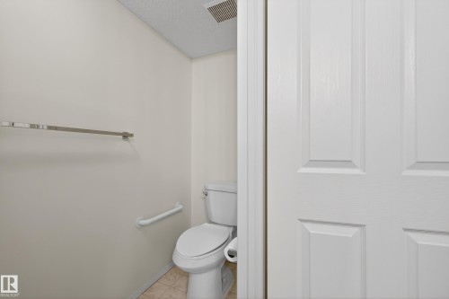 The bathroom features a toilet, a grab bar, and a towel bar - 106 15499 Castle Downs Road, Edmonton, AB - Indoor Photo Showing Bathroom