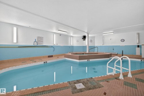 Indoor pool area featuring a rectangular pool, a separate hot tub, and a tiled surround - 106 15499 Castle Downs Road, Edmonton, AB - Indoor Photo Showing Other Room With In Ground Pool