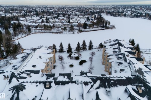 This property offers serene views of a frozen body of water and the surrounding neighborhood - 106 15499 Castle Downs Road, Edmonton, AB - Outdoor With View