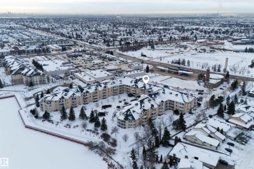 Aerial view of the property and its surrounding area, featuring a multi-story building with snow-covered roofs and balconies - 106 15499 Castle Downs Road, Edmonton, AB - Outdoor With View
