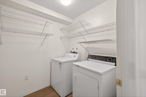 Dedicated laundry area featuring a washer and dryer, practical wire shelving, and light-colored flooring - 106 15499 Castle Downs Road, Edmonton, AB - Indoor