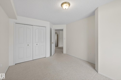 This room features neutral-toned carpeting and light-colored walls, providing a versatile backdrop - 106 15499 Castle Downs Road, Edmonton, AB - Indoor