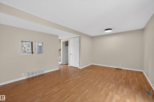 Living area featuring hardwood flooring, light-colored walls, and a contemporary ceiling light fixture - 3301 139 Avenue, Edmonton, AB - Indoor Photo Showing Other Room