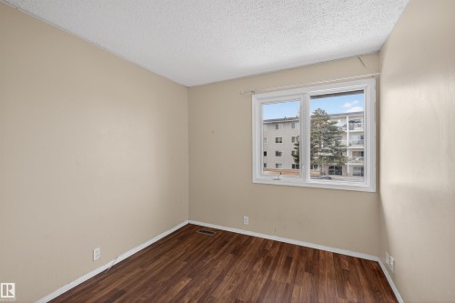 This room features durable wood-look flooring and a window that provides natural light - 3301 139 Avenue, Edmonton, AB - Indoor Photo Showing Other Room
