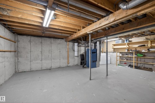 The unfinished basement offers a spacious area with exposed ceiling joists, concrete walls, and concrete flooring - 3301 139 Avenue, Edmonton, AB - Indoor Photo Showing Basement