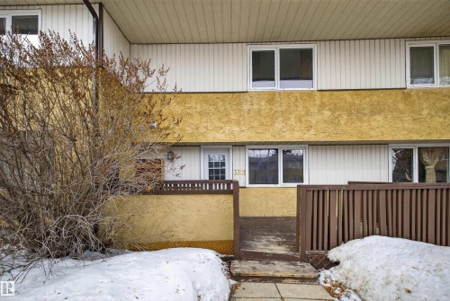 Exterior view of the property featuring a private deck, white-framed windows, and textured exterior finishes - 3301 139 Avenue, Edmonton, AB - Outdoor