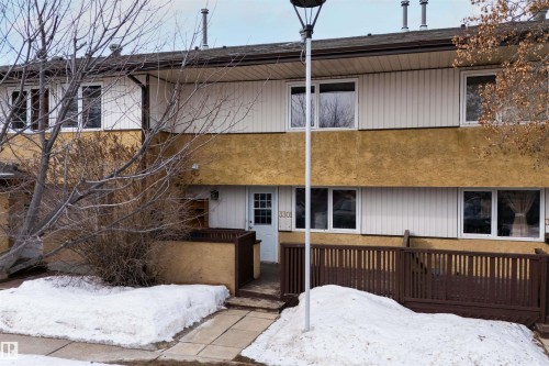 The property exterior features a white front door, white window frames, and brown fencing - 3301 139 Avenue, Edmonton, AB - Outdoor