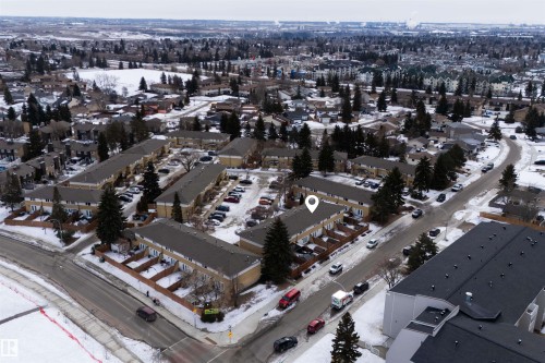 Aerial view showcasing the property within a community featuring residential buildings with dark roofs, surrounded by mature trees, and street parking - 3301 139 Avenue, Edmonton, AB - Outdoor With View