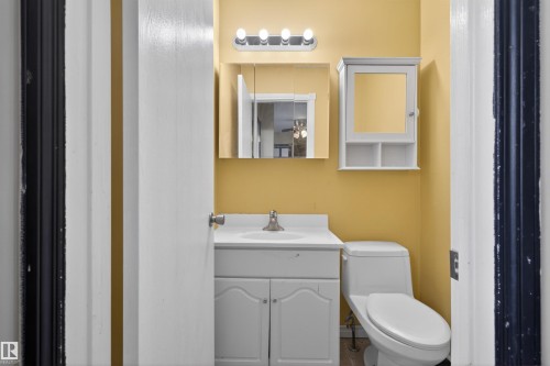Bathroom featuring a white vanity with an integrated sink, a wall-mounted medicine cabinet, and a toilet - 3301 139 Avenue, Edmonton, AB - Indoor Photo Showing Bathroom