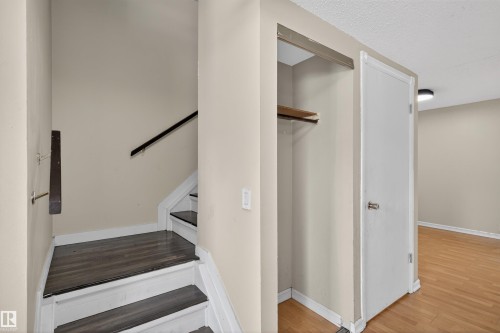The property features a staircase with dark wood treads and white risers, complemented by a dark wood handrail - 3301 139 Avenue, Edmonton, AB - Indoor Photo Showing Other Room