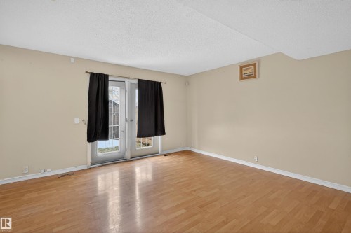 This inviting room features hardwood flooring and light-toned walls - 3301 139 Avenue, Edmonton, AB - Indoor Photo Showing Other Room