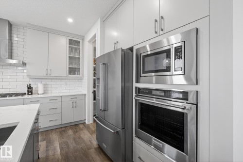 The kitchen features stainless steel appliances, including a microwave, oven, and refrigerator - 13 Bilodeau Crescent, Beaumont, AB - Indoor Photo Showing Kitchen With Upgraded Kitchen