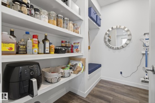 This space features white shelving, providing ample storage - 13 Bilodeau Crescent, Beaumont, AB - Indoor Photo Showing Other Room