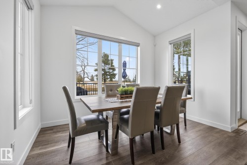 Dining area featuring hardwood floors and large windows providing views of the outdoors - 13 Bilodeau Crescent, Beaumont, AB - Indoor Photo Showing Dining Room