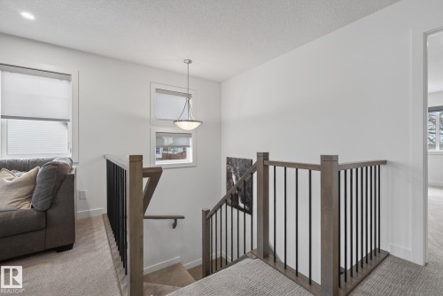 This space features light-colored walls and carpeted flooring - 13 Bilodeau Crescent, Beaumont, AB - Indoor Photo Showing Other Room