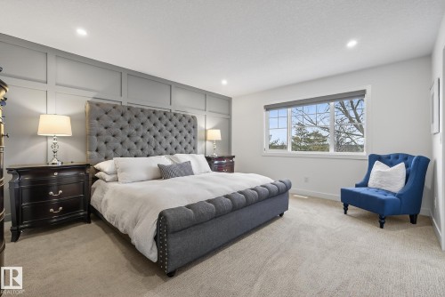The property features a spacious bedroom with light-colored carpet flooring, a large window providing natural light, and recessed ceiling lights - 13 Bilodeau Crescent, Beaumont, AB - Indoor Photo Showing Bedroom