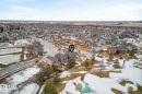 Aerial view of the property and its surrounding neighborhood, featuring residential homes, paved streets, and a nearby golf course with visible greens - 13 Bilodeau Crescent, Beaumont, AB  - Outdoor With View 