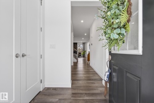The entryway features an open front door with a window, white walls, and wood flooring - 13 Bilodeau Crescent, Beaumont, AB - Indoor Photo Showing Other Room