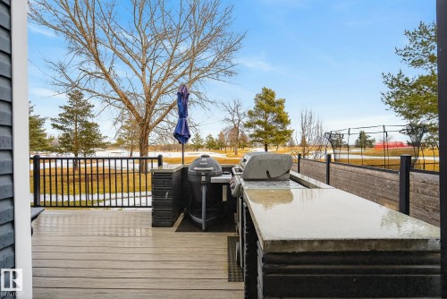 The property features an outdoor deck with a built-in outdoor kitchen, including a grill and extensive counter space - 13 Bilodeau Crescent, Beaumont, AB - Outdoor With Deck Patio Veranda