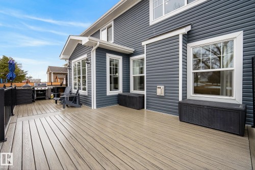 The property features a spacious outdoor deck with wood-look decking and dark gray siding - 13 Bilodeau Crescent, Beaumont, AB - Outdoor With Exterior