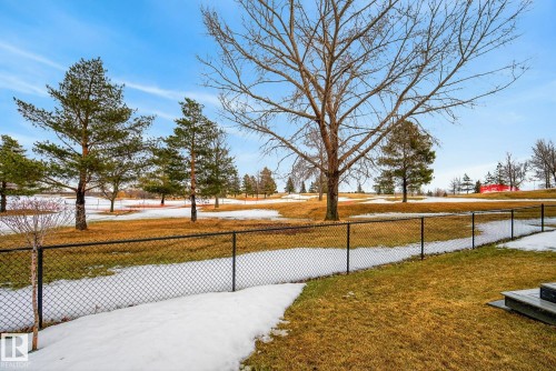 The property features a private fenced yard with views of a natural landscape, including mature trees and rolling terrain - 13 Bilodeau Crescent, Beaumont, AB - Outdoor