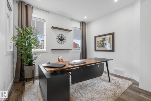 This versatile room features white walls, recessed lighting, and rich wood-toned flooring - 13 Bilodeau Crescent, Beaumont, AB - Indoor