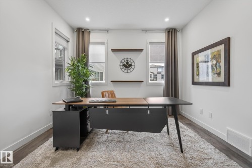 This versatile room features white walls, dark wood-style flooring, and recessed lighting - 13 Bilodeau Crescent, Beaumont, AB - Indoor Photo Showing Other Room