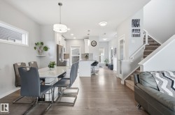 Open concept living space featuring hardwood floors, a dining area, and a staircase with carpeted treads - 