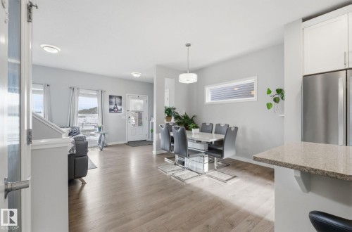 This property features light-colored flooring throughout, with a dining area illuminated by a pendant light - 17498 76 St Nw, Edmonton, AB - Indoor