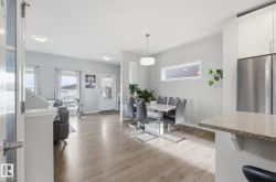 This property features light-colored flooring throughout, with a dining area illuminated by a pendant light - 