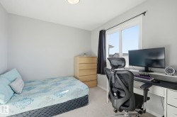 Bedroom with light gray walls, a window with dark curtains, and light-colored carpet - 