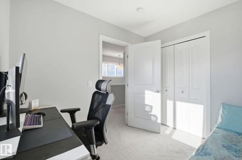 This room features light-colored walls and carpeting, a white door, and white bi-fold closet doors - 17498 76 St Nw, Edmonton, AB - Indoor Photo Showing Office