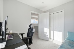 This room features light-colored walls and carpeting, a white door, and white bi-fold closet doors - 