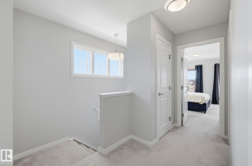 The property features a hallway with light gray walls, white trim, and light-colored carpeting - 17498 76 St Nw, Edmonton, AB - Indoor Photo Showing Other Room
