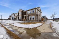 The property features a two-story exterior with light brown siding and white window trim - 