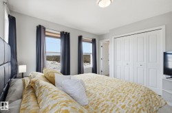 The property features a bedroom with two windows, a ceiling light fixture, and white bi-fold closet doors - 