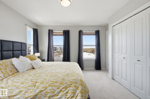 This room features light-colored walls, carpeted flooring, and a ceiling-mounted light fixture - 17498 76 St Nw, Edmonton, AB - Indoor Photo Showing Bedroom