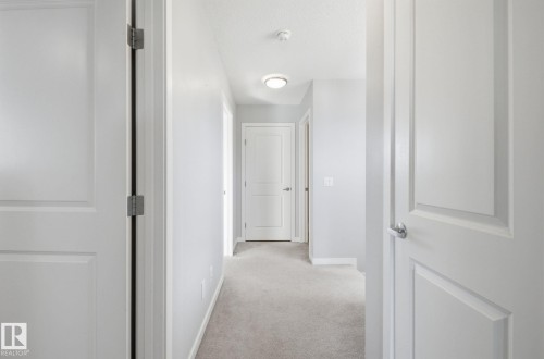 Hallway with light gray walls, white trim, and light gray carpet - 17498 76 St Nw, Edmonton, AB - Indoor Photo Showing Other Room